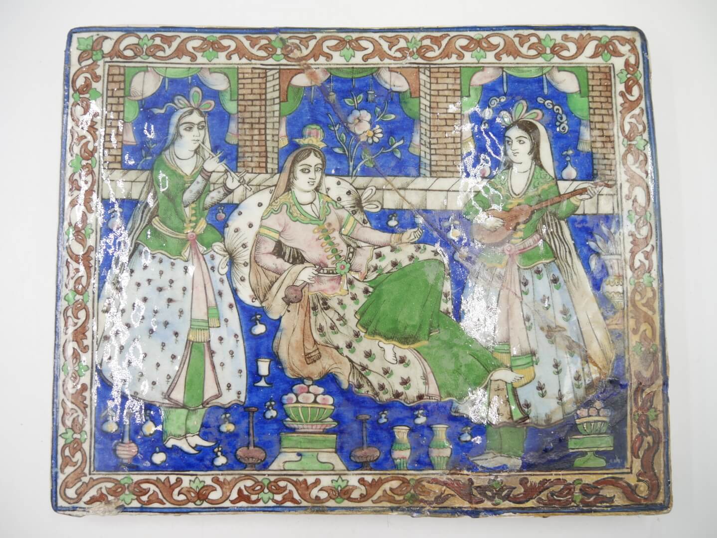 IRAN QÂJÂR - Seconde moitié du XIXe siècle - Plaque en céramique ornée d’une scène de délassement. Carreau de revêtement
